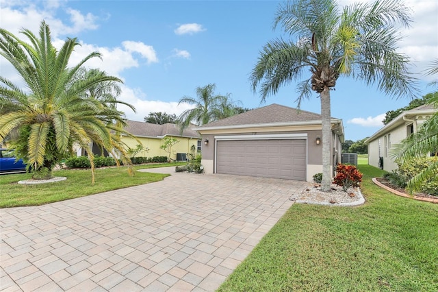 view of front of house with cooling unit, a front yard, and a garage