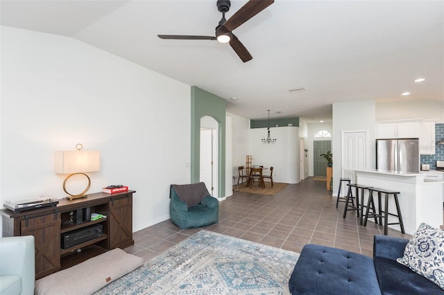 tiled living room featuring ceiling fan and vaulted ceiling