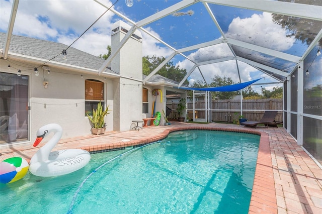 view of swimming pool featuring a patio and glass enclosure