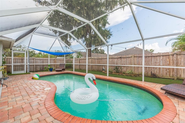 view of swimming pool with a patio area and a lanai