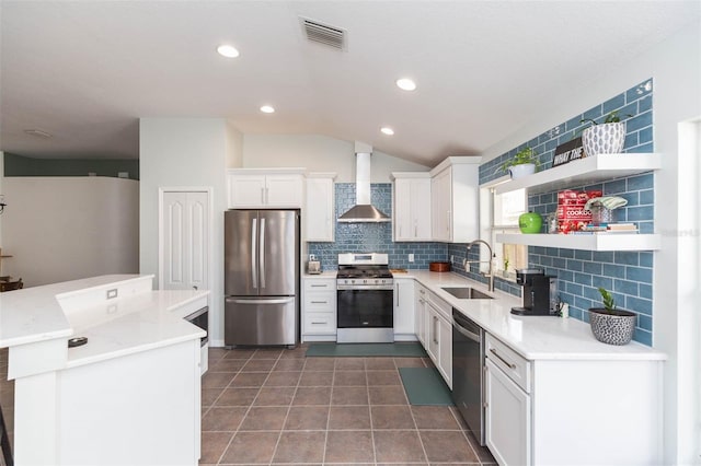 kitchen featuring decorative backsplash, stainless steel appliances, sink, wall chimney range hood, and white cabinetry