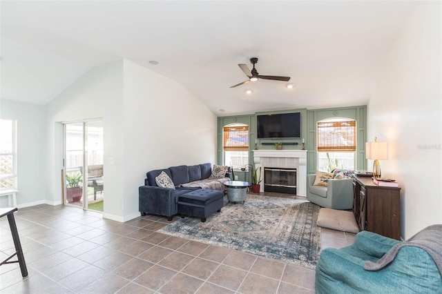 tiled living room featuring ceiling fan, a healthy amount of sunlight, lofted ceiling, and a fireplace