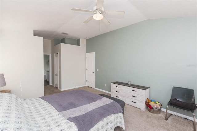 bedroom with ensuite bath, vaulted ceiling, ceiling fan, light colored carpet, and a closet