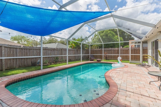 view of pool with glass enclosure and a patio