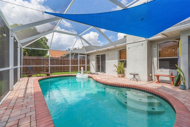 view of pool with a patio and glass enclosure