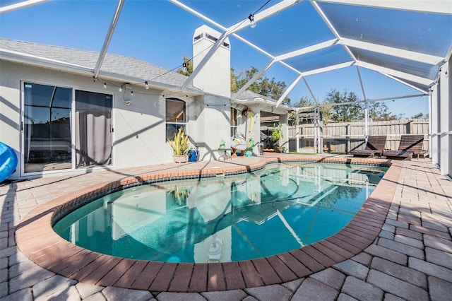 view of pool with a patio area and glass enclosure