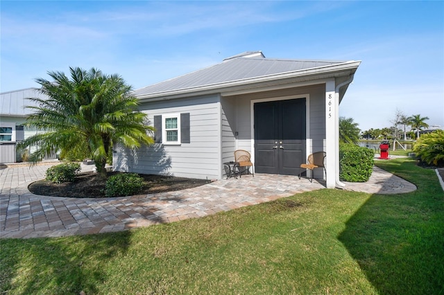 rear view of property featuring a lawn and a patio area