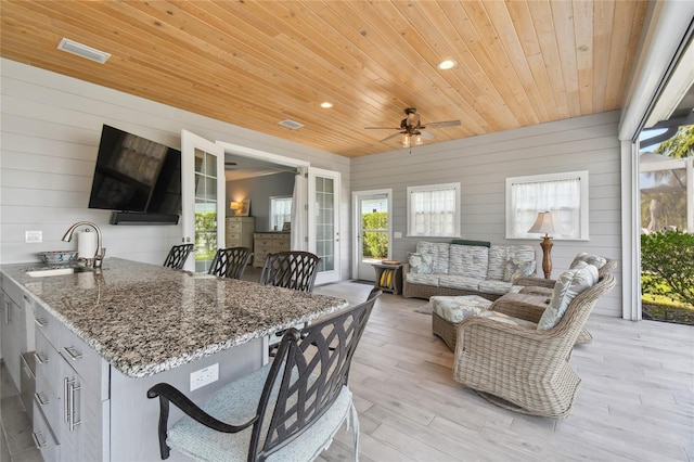 interior space with ceiling fan, wood ceiling, and sink