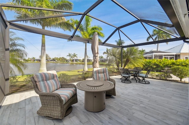 view of patio featuring a water view and a lanai