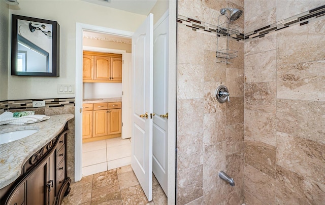 bathroom featuring tiled shower and vanity