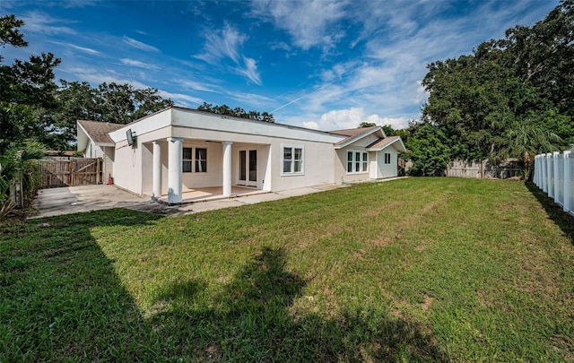 back of house with a yard and a patio