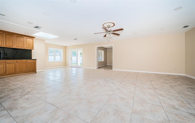 unfurnished living room featuring ceiling fan and light tile patterned floors