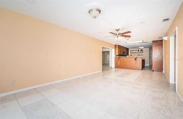 unfurnished living room featuring light tile patterned flooring and ceiling fan