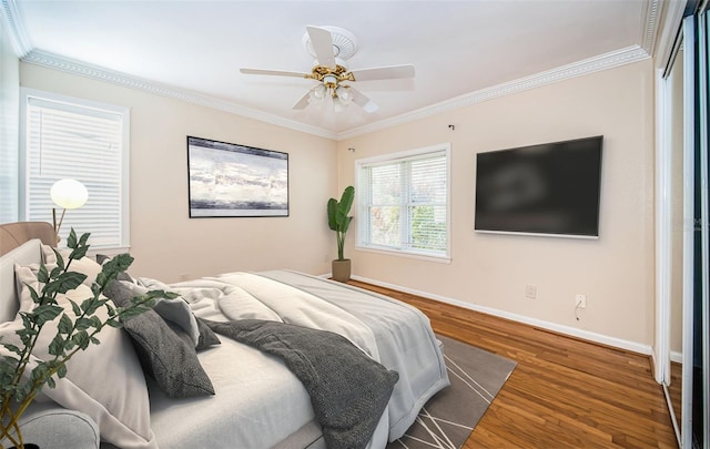 bedroom featuring ceiling fan, dark hardwood / wood-style floors, and crown molding