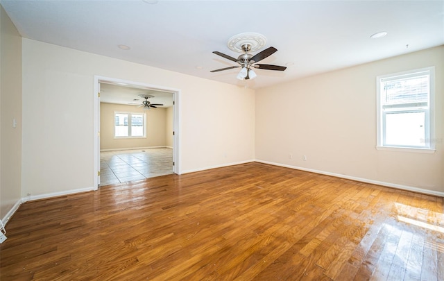 unfurnished room with ceiling fan and hardwood / wood-style flooring