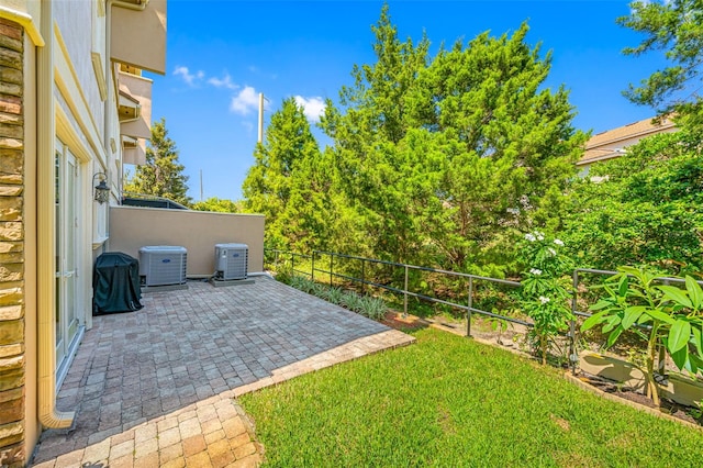 view of yard with central air condition unit and a patio area