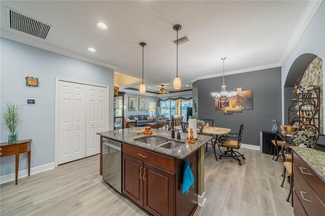 kitchen with light stone counters, sink, hanging light fixtures, light hardwood / wood-style flooring, and stainless steel dishwasher