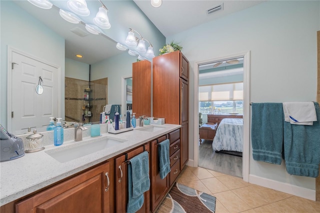 bathroom with tile patterned flooring, vanity, and tiled shower