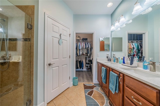 bathroom with vanity, a shower with shower door, and tile patterned flooring