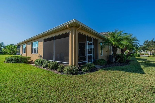 view of property exterior featuring a sunroom and a yard