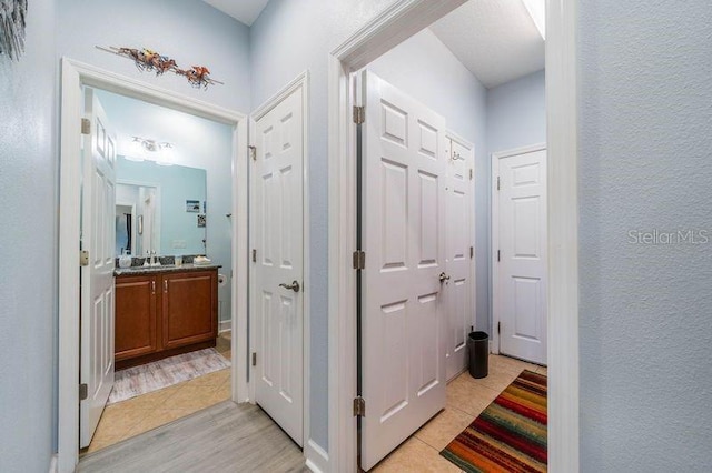 hall with light hardwood / wood-style flooring and sink