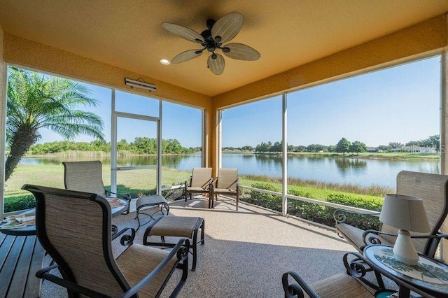 sunroom featuring a water view and ceiling fan