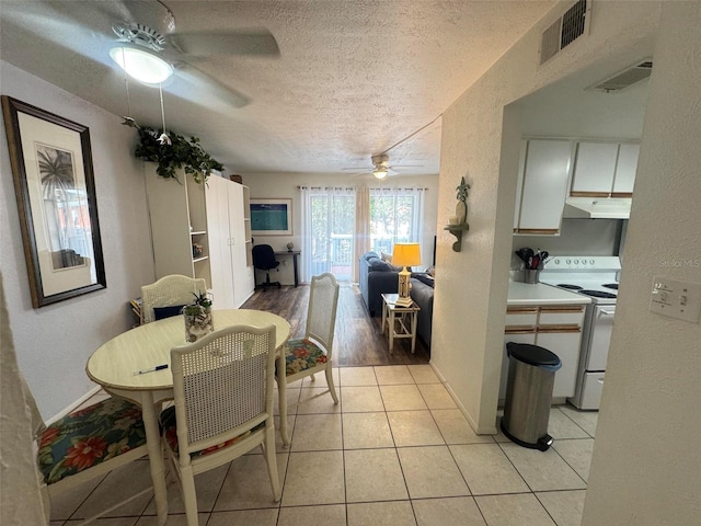 dining area featuring a textured ceiling, ceiling fan, and visible vents
