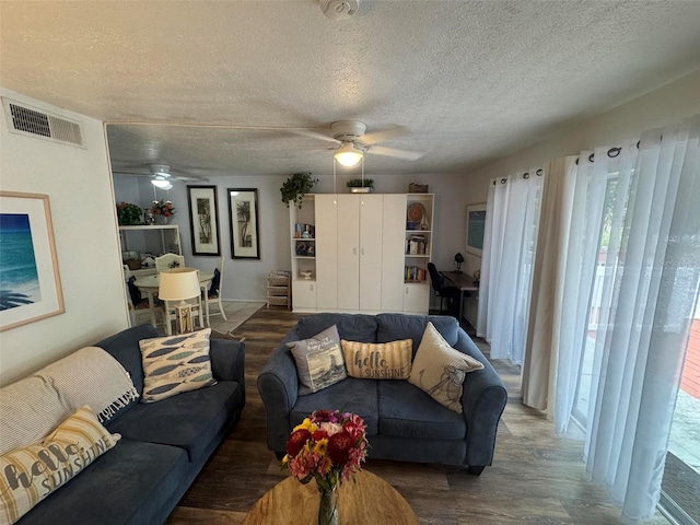 living room with visible vents, a textured ceiling, ceiling fan, and wood finished floors