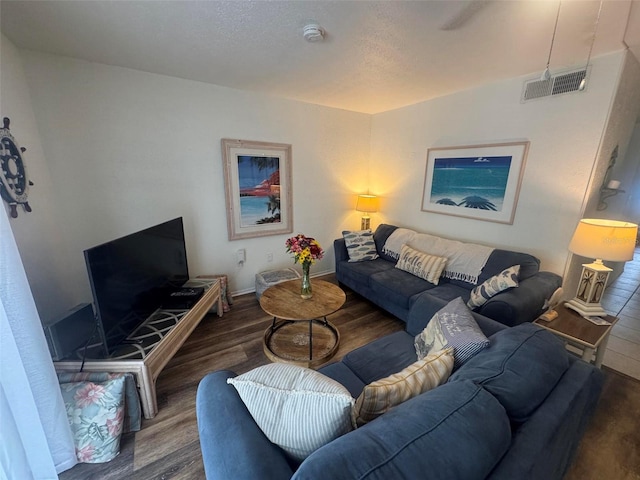 living area with visible vents, baseboards, and wood finished floors