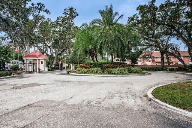 view of street with a gated entry, curbs, and a gate