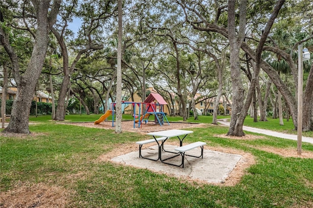 view of property's community featuring a lawn and playground community
