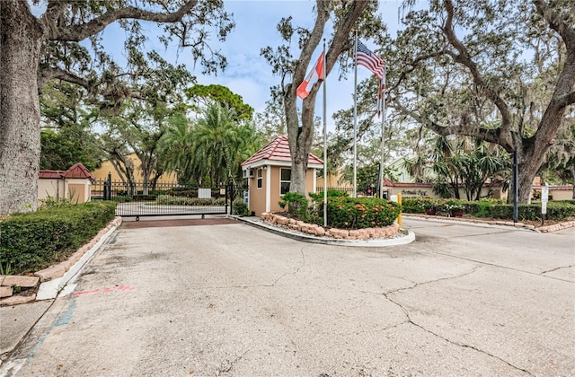 view of street featuring a gate, curbs, and a gated entry