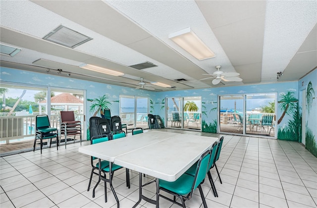 sunroom / solarium featuring a wealth of natural light, visible vents, and ceiling fan