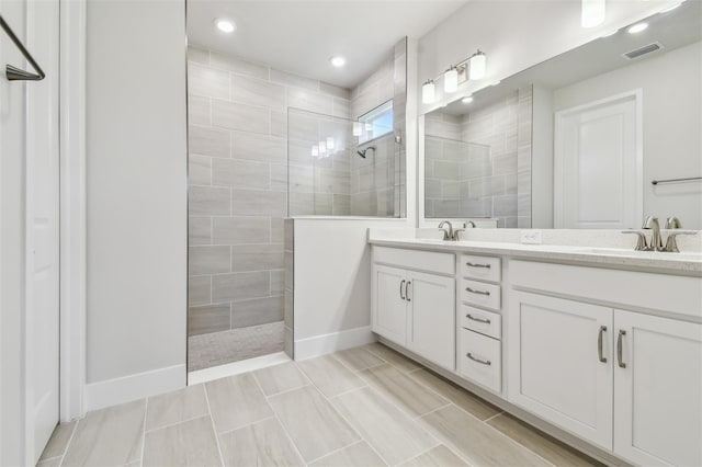 bathroom featuring vanity and a tile shower