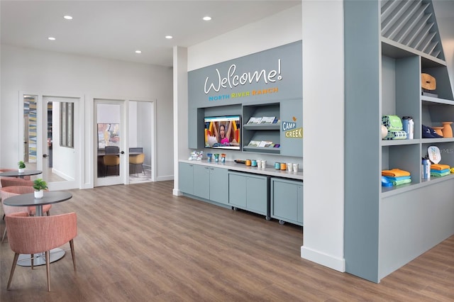 living room with built in shelves and hardwood / wood-style floors