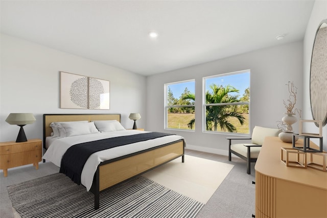 bedroom with light colored carpet and baseboards