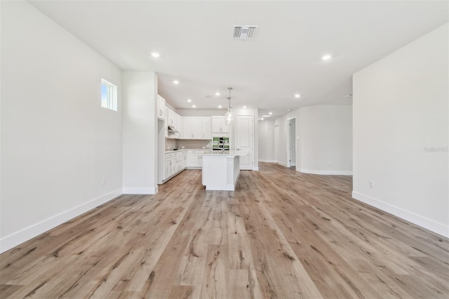unfurnished living room with recessed lighting, visible vents, light wood finished floors, and baseboards