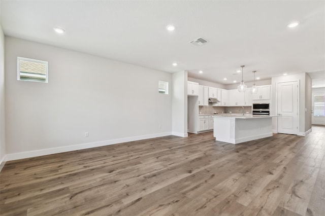 kitchen featuring white cabinets, baseboards, and visible vents