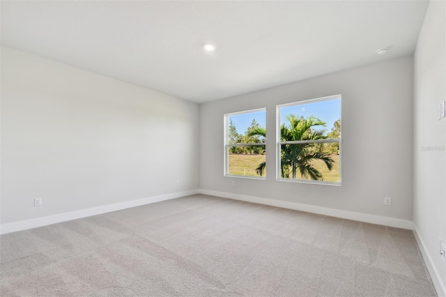 carpeted spare room featuring baseboards and recessed lighting