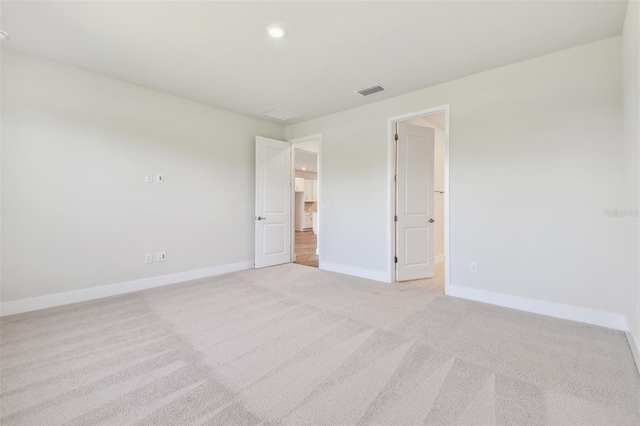 spare room with light carpet, baseboards, and recessed lighting