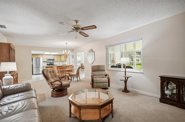 living room with ceiling fan with notable chandelier, a textured ceiling, and light colored carpet