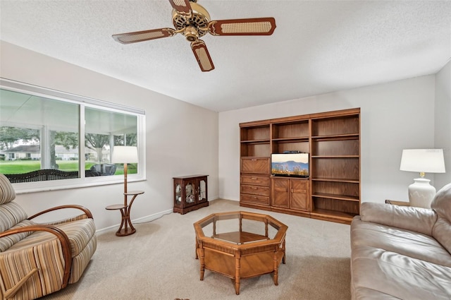 carpeted living room with ceiling fan and a textured ceiling