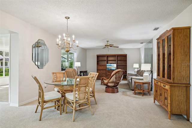 carpeted dining area with a textured ceiling and ceiling fan with notable chandelier