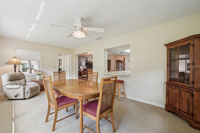 carpeted dining area with ceiling fan and a textured ceiling