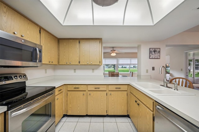 kitchen with a healthy amount of sunlight, stainless steel appliances, sink, and light tile patterned floors