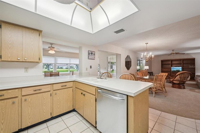 kitchen with dishwasher, kitchen peninsula, light carpet, sink, and decorative light fixtures