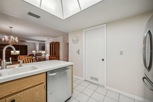 kitchen featuring stainless steel appliances, sink, pendant lighting, light tile patterned floors, and a chandelier