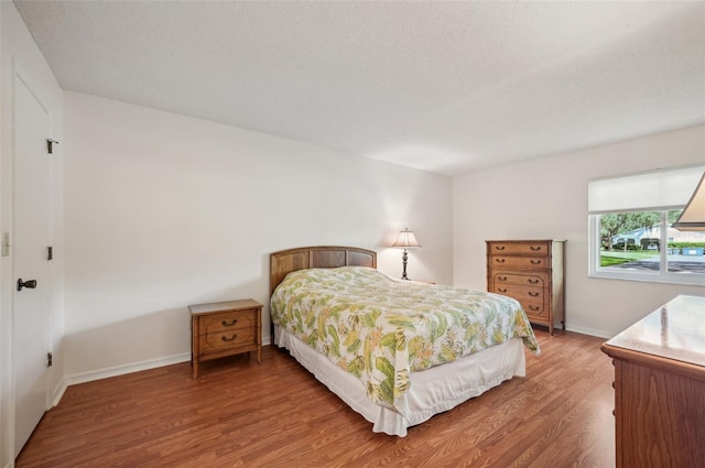 bedroom with a textured ceiling and hardwood / wood-style floors