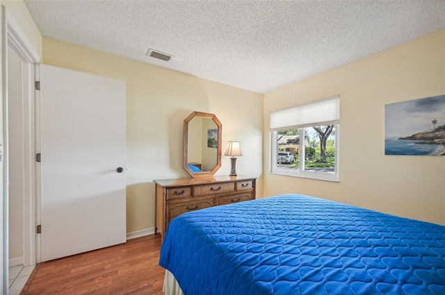 bedroom featuring a textured ceiling and wood-type flooring