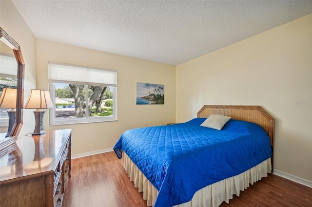 bedroom with hardwood / wood-style flooring and a textured ceiling